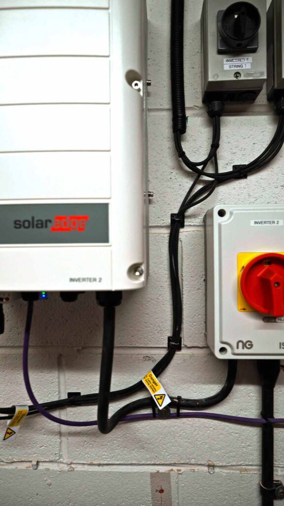 SolarEdge inverter and electrical isolator on wall