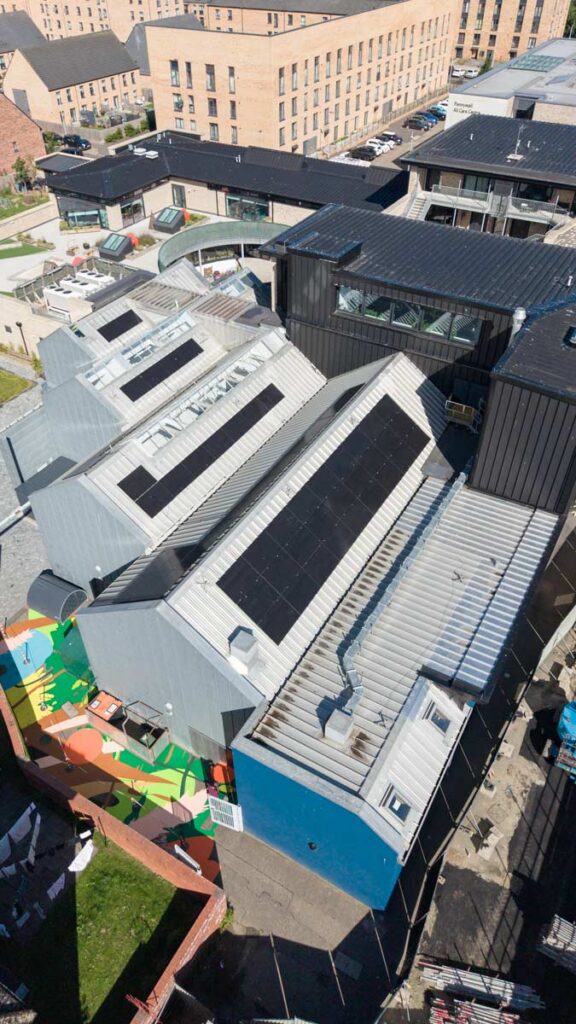 Aerial view of solar panels on urban community building roof