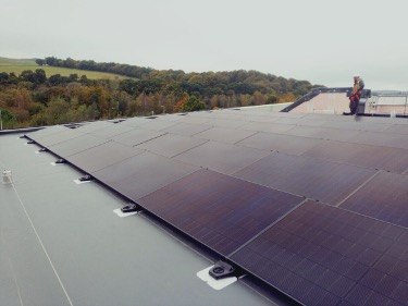 Rooftop solar panels overlooking wooded countryside