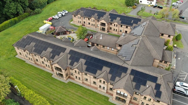 Aerial view of residential complex with rooftop solar panels